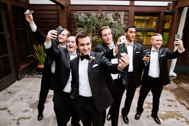 wedding day selfie of the groom and groomsmen taking their own selfies