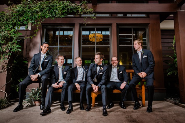 the groomsmen sit together looking poised